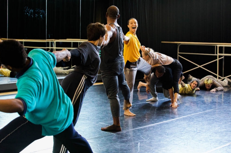 Dancers in mid performance, holding to one another's arms